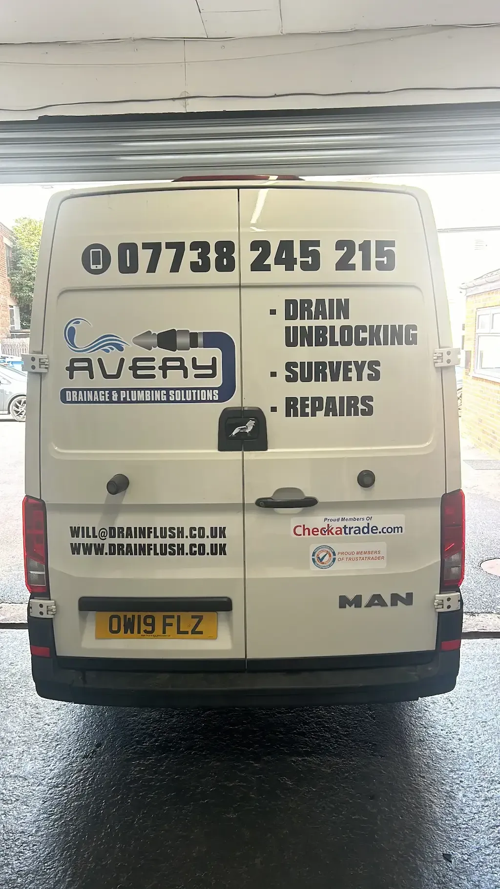 Rear view of an Avery Drainage Solutions van with branding and services listed.